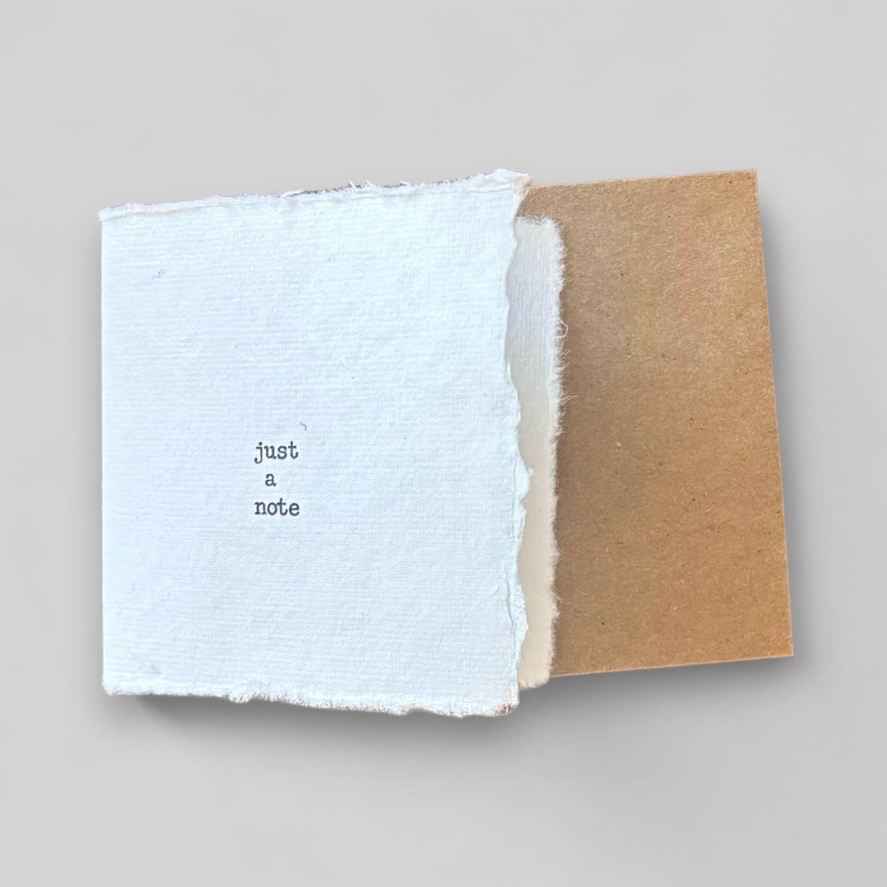 Small white handmade typewritten just a note card